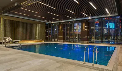a large swimming pool in a building with a building at Hilton Istanbul Kozyatagi in Istanbul