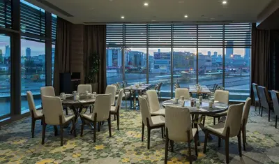 a restaurant with tables and chairs and a large window at Hilton Istanbul Kozyatagi in Istanbul