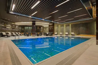 a large swimming pool with blue water in a building at Hilton Istanbul Kozyatagi in Istanbul