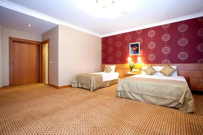 a hotel room with two beds and purple walls at Sefa Hotel 2 Çorlu in Corlu