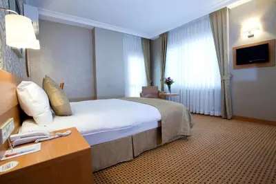 a hotel room with a large bed and a table at Sefa Hotel 2 Çorlu in Corlu