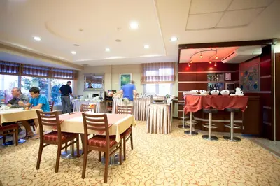 a restaurant with tables and chairs and people eating at Sefa Hotel 2 Çorlu in Corlu