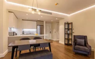 a living room with a table and chairs and a kitchen at Taksim 360 Luxe Apartment Prime Istanbul Location in Istanbul