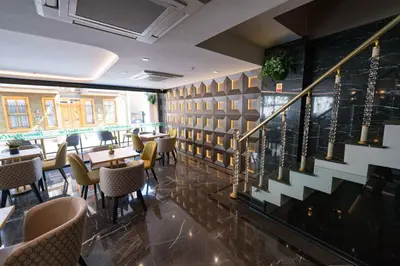 a restaurant with tables and chairs and a staircase at Costera Hotel in Istanbul