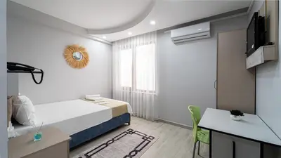 a small room with a bed and a desk and a television at KUMBAĞ ŞEHRİ SARAY APART OTEL in Tekirdag