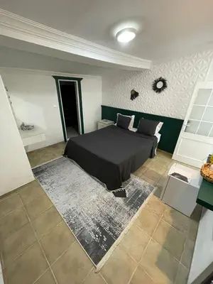 a bedroom with a bed with a black comforter at KİRAZ BEACH OTEL in Erdek