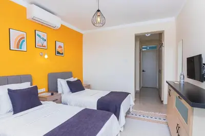 a hotel room with two beds and a flat screen tv at KİRAZ BEACH OTEL in Erdek
