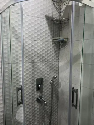 a shower stall with a glass door in a bathroom at Middle Village in Istanbul