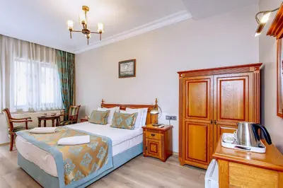 a bedroom with a bed and a desk with a telephone at Hotel Saba in Istanbul