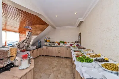 a large kitchen with a long table filled with food at Olimpic Hotel in Istanbul