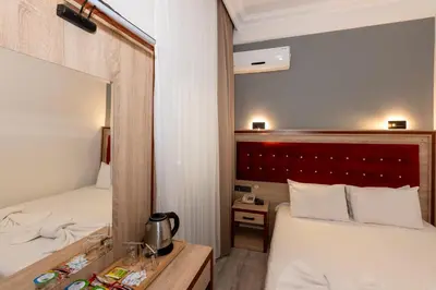 a hotel room with two beds and a mirror at Olimpic Hotel in Istanbul