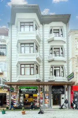 a tall white building with people sitting in front of it at Olimpic Hotel in Istanbul