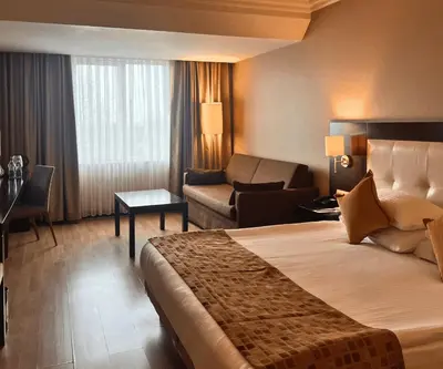 a hotel room with a large bed and a couch at Eresin Hotels Topkapı in Istanbul