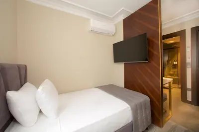 a hotel room with a bed and a flat screen tv at Yusufpasa Konagi - Special Class in Istanbul