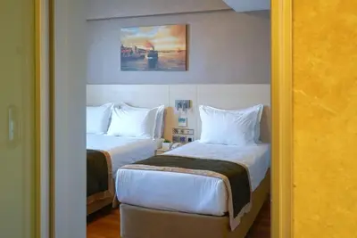 a hotel room with two beds and a painting on the wall at Hotel Troya in Istanbul