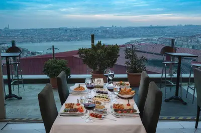 a table with food and wine glasses on a balcony at Hotel Troya in Istanbul