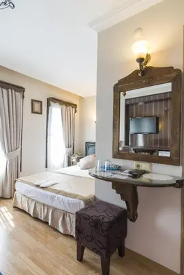 a hotel room with a bed and a mirror at Naz Wooden House Inn in Istanbul