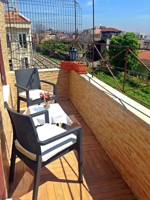 a patio with two chairs and a table on a balcony at Naz Wooden House Inn in Istanbul