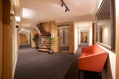 a hallway in a building with a staircase and orange bench at Barin Hotel in Istanbul