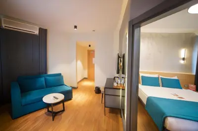 a hotel room with a bed and a blue couch at Barin Hotel in Istanbul
