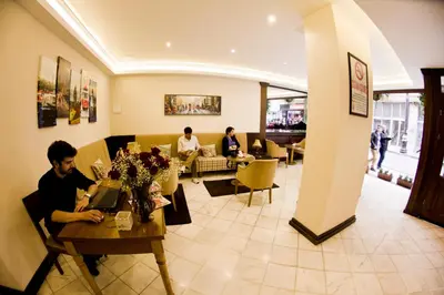 a group of people sitting at a table in a restaurant at Ilkay Hotel in Istanbul