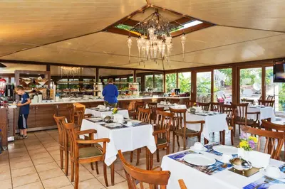 a restaurant with white tables and chairs and a chandelier at Zeynep Sultan Hotel in Istanbul