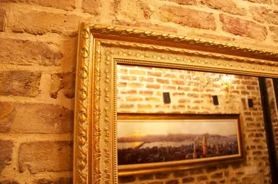 a gold picture frame hanging on a brick wall at Art Nouveau Galata in Istanbul