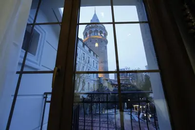 a view of a clock tower through a window at Art Nouveau Galata in Istanbul