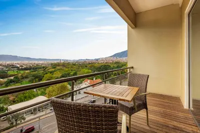 a balcony with a wooden table and chairs at Hotel Çelik Palas Convention Center & Thermal SPA in Bursa