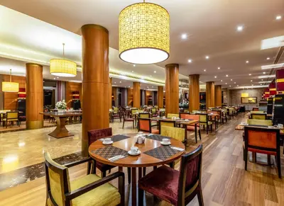 a restaurant with tables and chairs in a room at Hotel Çelik Palas Convention Center & Thermal SPA in Bursa