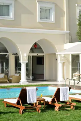two lounge chairs on the grass next to a swimming pool at Holiday Inn Istanbul City by IHG in Istanbul