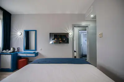 a bedroom with a large bed and a blue desk at Lapis Inn Hotel & Spa ( Ex. Ambassador Hotel) in Istanbul