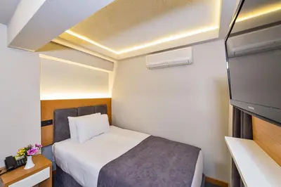 a small room with a bed and a tv at Bergama Hotel Old City in Istanbul