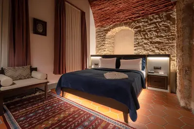a bedroom with a bed and a stone wall at Han 1772 Hotel in Istanbul