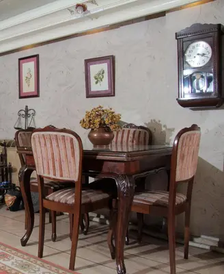 a dining room table with chairs and a clock on the wall at Hotel Nezih Istanbul in Istanbul