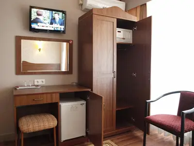a small room with a desk and a mirror at Hotel Nezih Istanbul in Istanbul