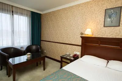a hotel room with a bed and a chair and a table at Topkapi Inter Istanbul Hotel in Istanbul