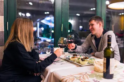 a man and woman sitting at a table with wine glasses at Garden House Hotel - Special Class in Istanbul