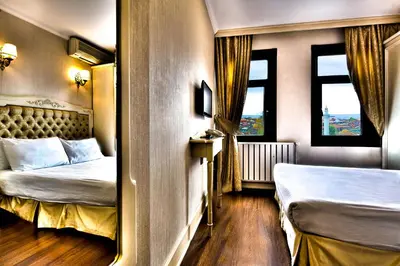 a bedroom with two beds and two windows at Hotel Historia-Special Category in Istanbul