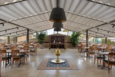 a restaurant with wooden tables and chairs and a fountain at Armada Istanbul Old City Hotel in Istanbul