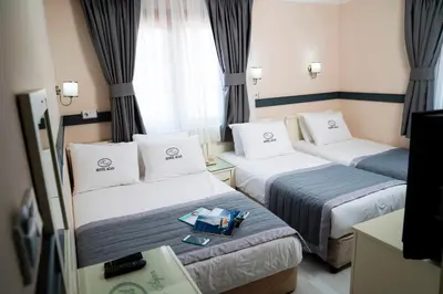a hotel room with two beds and a tv at Hotel Agan Oldcity Istanbul in Istanbul