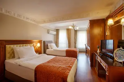 a hotel room with two beds and a television at Hotel Sumengen in Istanbul