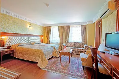 a hotel room with a bed and a tv at Hotel Sumengen in Istanbul
