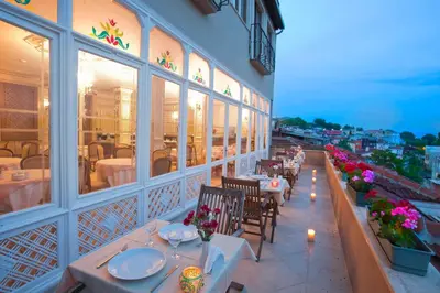 a restaurant with tables and chairs on a balcony at Hotel Sumengen in Istanbul