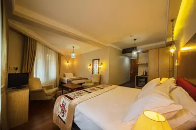 a hotel room with a large bed and a living room at Hippodrome Hotel in Istanbul