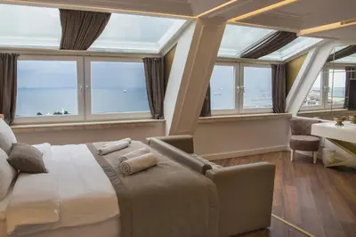 a bedroom with a bed and a desk and windows at Mina Hotel - Special Category in Istanbul