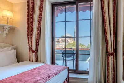 a bedroom with a bed and a window with a balcony at The And Hotel Sultanahmet - Special Category in Istanbul
