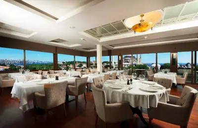 a restaurant with white tables and chairs and windows at The And Hotel Sultanahmet - Special Category in Istanbul