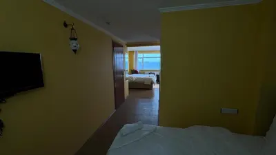 a yellow room with a bed and a television at Cosmopolitan Park Hotel in Istanbul