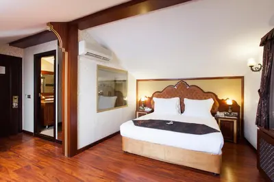 a bedroom with a large bed with a wooden headboard at Ottoman Hotel Imperial-Special Category in Istanbul